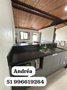 a kitchen with a black counter top in a room at Canto dos pássaros in Tramandaí +2 photos