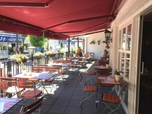 una fila de mesas y sillas en un patio en Bergischer Hof en Overath