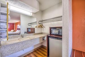 a small bathroom with a sink and a microwave at Hillcrest Inn & Suites Ozona in Ozona