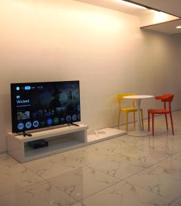 a room with a tv and two chairs and a table at Koregon Hotel in Fort Stotsenburg