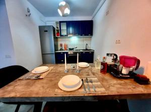 a kitchen with a wooden table with plates on it at Panoramic Self Check-in Underground Parking in Iaşi