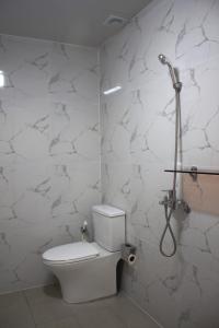 a bathroom with a toilet and a shower at Koregon Hotel in Fort Stotsenburg