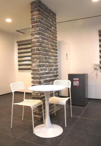 a table and chairs in a room with a brick wall at Koregon Hotel in Fort Stotsenburg