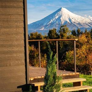 a view of a snow covered mountain from a house at Volcano Suites in Puyehue