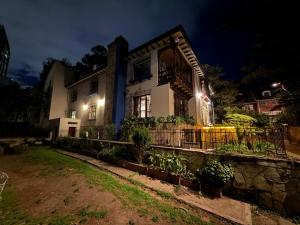 a house with a fence in front of it at night at Sereno Hostels in Bogotá +10 photos
