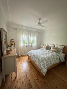 a bedroom with a bed and a ceiling fan at The Seaside Haven Umina in Umina