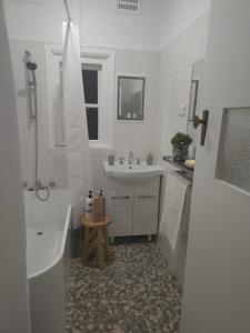 a white bathroom with a sink and a shower at The Seaside Haven Umina in Umina +6 photos