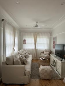 a living room with a white couch and a television at The Seaside Haven Umina in Umina