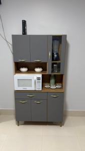 a kitchen with a microwave and a counter with dishes at Loft centro de Goiânia 1108 in Goiânia