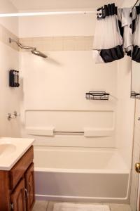 a white bathroom with a tub and a sink at Gano Street Retreat in Great Bend +15 photos
