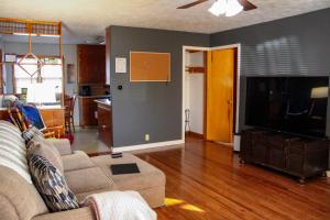 a living room with a couch and a flat screen tv at Gano Street Retreat in Great Bend