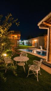 a table and chairs in a yard at night at Sitio em Capim Branco in Capim Branco