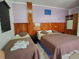 a hotel room with two beds and a sign that reads best inn at Hospedaje Cactus Experience in Puerto Villamil