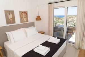 a bedroom with a bed with two towels on it at PETRA Luxury Villas in Agioi Apostoli +119 photos