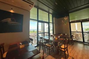a restaurant with tables and chairs and large windows at Tropical Executive Hotel APT 606 in Manaus