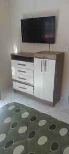 a living room with a tv and a dresser at Casa Nascer do Sol in Sangão