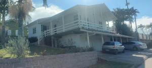a white house with two cars parked in front of it at Casa Nascer do Sol in Sangão