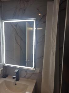 a bathroom with a large mirror and a sink at H Bella Mar Roses in Roses