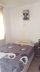 a bed in a room with a picture on the wall at El viajero relax in Malambo