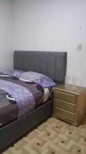 a bed and a nightstand with two glasses on it at El viajero relax in Malambo