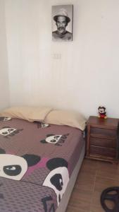 a bedroom with a bed and a picture of a man at El viajero relax in Malambo