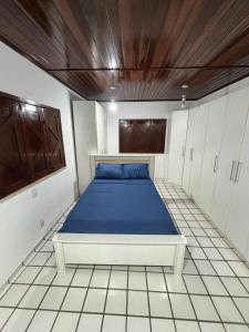 a bedroom with a bed with blue sheets in it at Araçagy Casa Mar in São José de Ribamar +6 photos