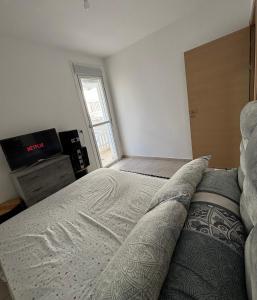 a bedroom with a large bed and a television at Résidence Calme Fnideq in Fnidek