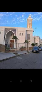 a car parked in front of a building with a clock tower at Résidence Calme Fnideq in Fnidek +3 photos