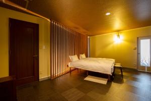 a bedroom with a bed in a room with yellow walls at mahoratto in Aomori