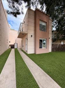a house with a walkway in front of a yard at Cabaña Fiorella in Santa Teresita
