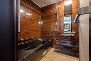 a bathroom with a tub and a shower with wooden walls at mahoratto in Aomori +16 photos