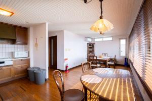 a kitchen and dining room with a table and chairs at mahoratto in Aomori