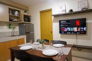 a kitchen with a table with chairs and a yellow door at Cozy 2BR Retreat at 8 Spatial Davao in Davao City