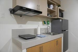 a kitchen with a sink and a stove at Cozy 2BR Retreat at 8 Spatial Davao in Davao City