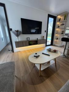 a living room with a table and a flat screen tv at MODULAR NUEVA l in San Luis