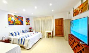 a bedroom with a bed and a flat screen tv at Edelmon't Beach in Los Órganos