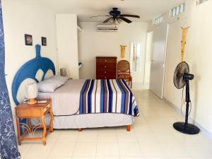 a bedroom with a bed and a table with a fan at Oasis del Mar- Departamento Palma in Progreso +6 photos