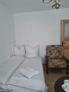 a bed with two pillows and a chair in a room at Apartament Centrum Zgorzelec in Zgorzelec +4 photos