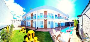 a large house with a swimming pool in front of it at Praia Studios in Vila Velha
