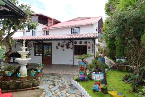 a white house with a fountain in the yard at Finca eventos Dalubsu in Silvania