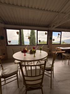 a dining room with a table and chairs and windows at Finca eventos Dalubsu in Silvania +47 photos