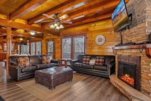 a living room with leather furniture and a fireplace at Cherokee Pool Lodge in Cosby