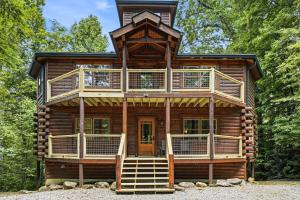 a cabin in the woods with a large deck at Cherokee Pool Lodge in Cosby