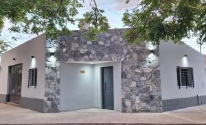 a building with a stone wall and a door at Departamentos Muy Eugenia in San Rafael