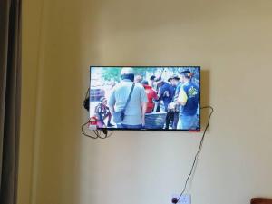 a flat screen tv hanging on a wall at RumahKuningHOMESTAY in Bachok