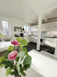 a white kitchen with a vase of flowers on a table at Central Large Double Room with free parking in Aalborg