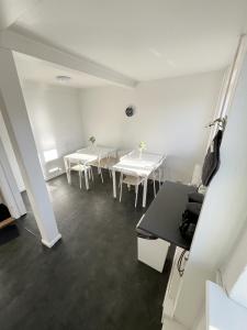 a room with white tables and white chairs at Central Large Double Room with free parking in Aalborg +7 photos