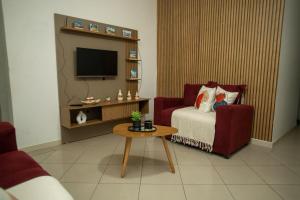 a living room with a red couch and a table at Apartamento Morada dos Sonhos in Lauro de Freitas
