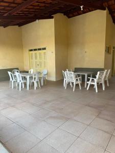 a group of white chairs and tables in a building at Casa de Praia do Morro Branco in Beberibe +5 photos