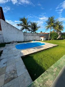 a swimming pool in a yard with palm trees at Casa de Praia do Morro Branco in Beberibe